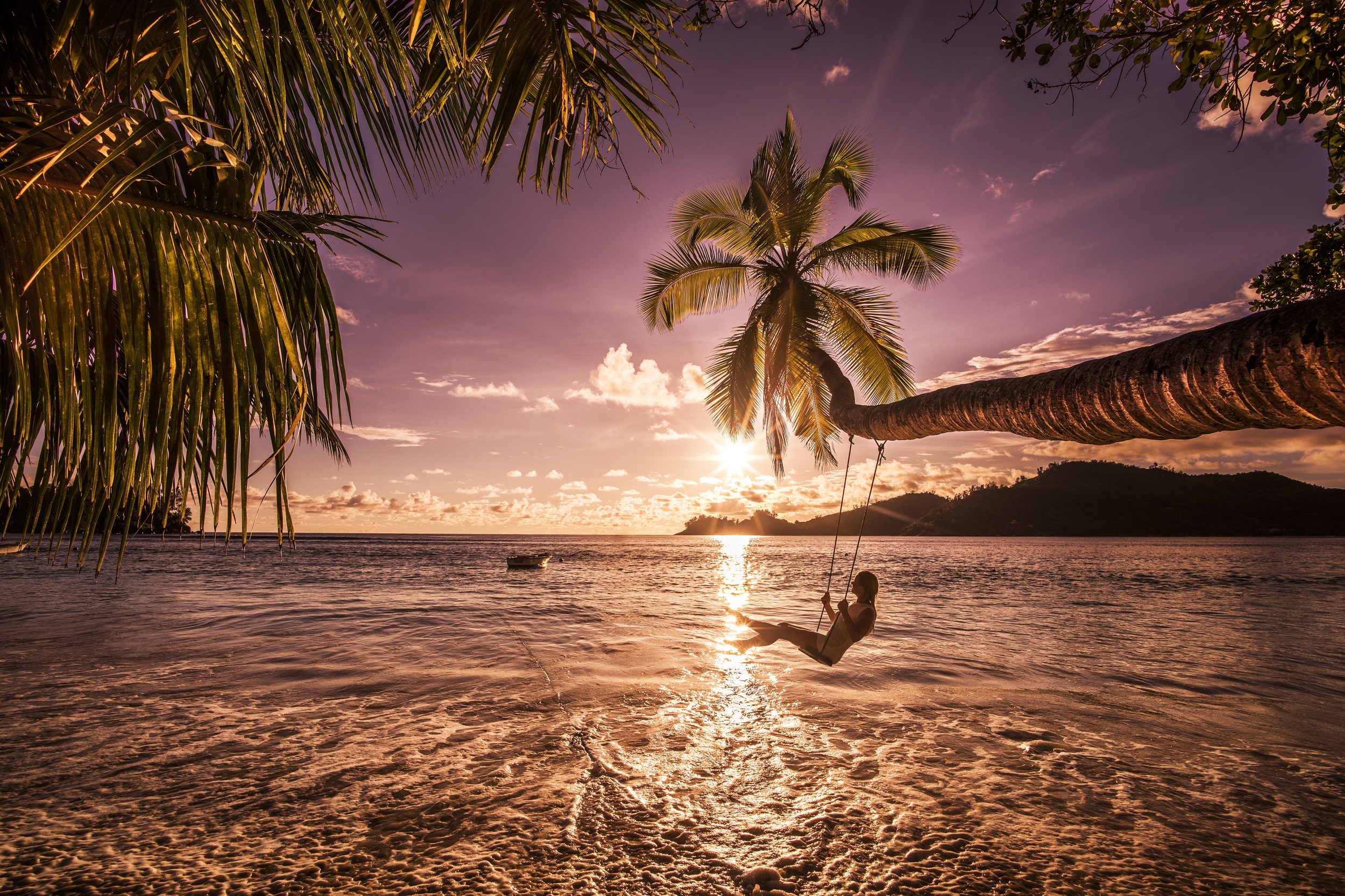 A woman on a swing on a Caribbean beach 