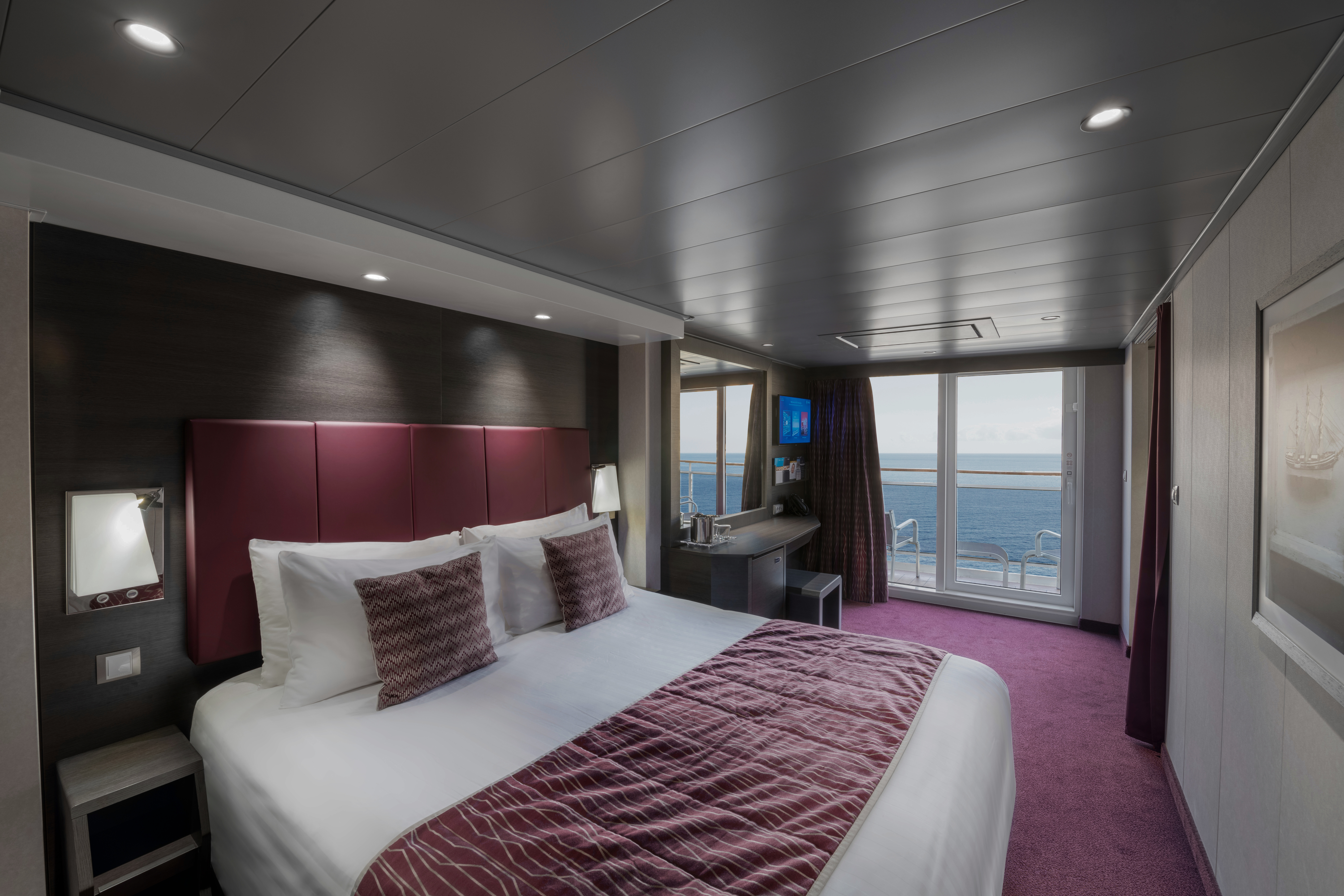 A balcony cabin room, with view of a bed, on MSC Grandiosa