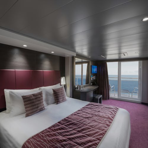 A balcony cabin room, with view of a bed, on MSC Grandiosa