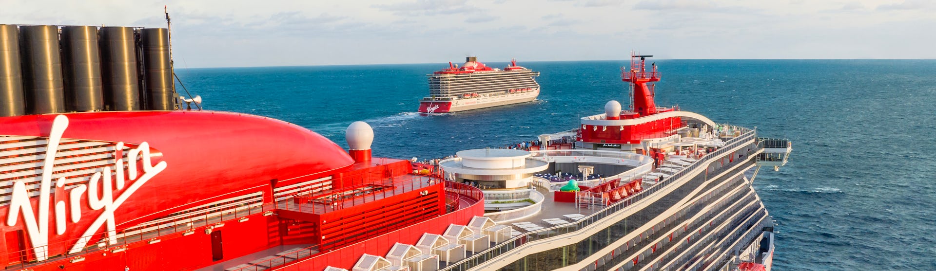 Two Virgin Voyages ships, Scarlet Lady and Valiant Lady, at sea