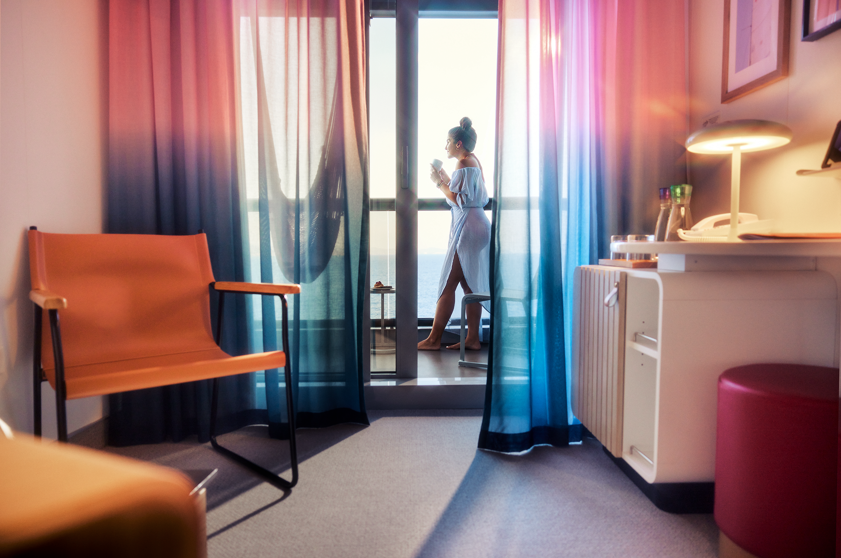 Woman standing on balcony of Virgin Voyages cabin