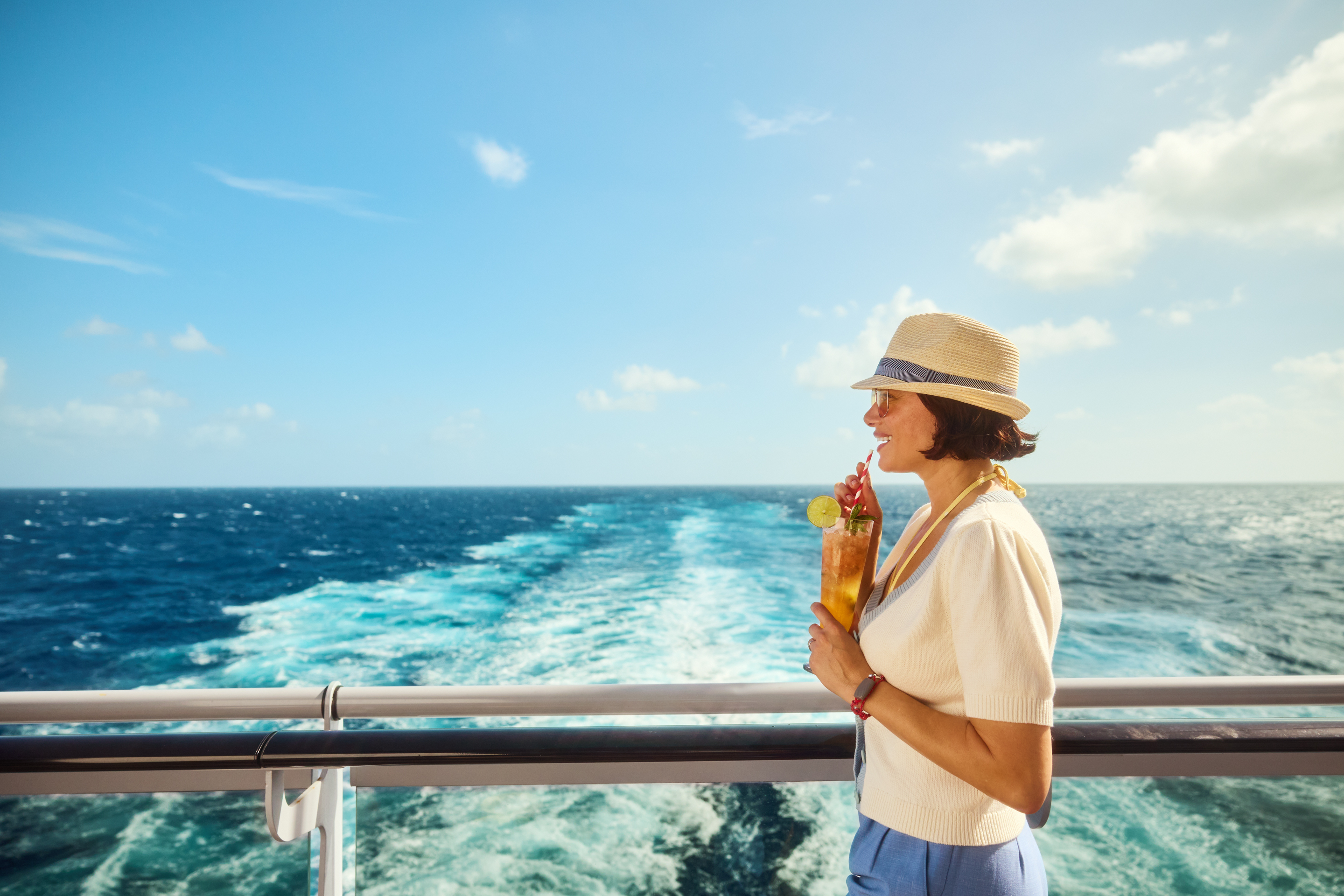 Woman with cocktail at aft of Virgin Voyages ship