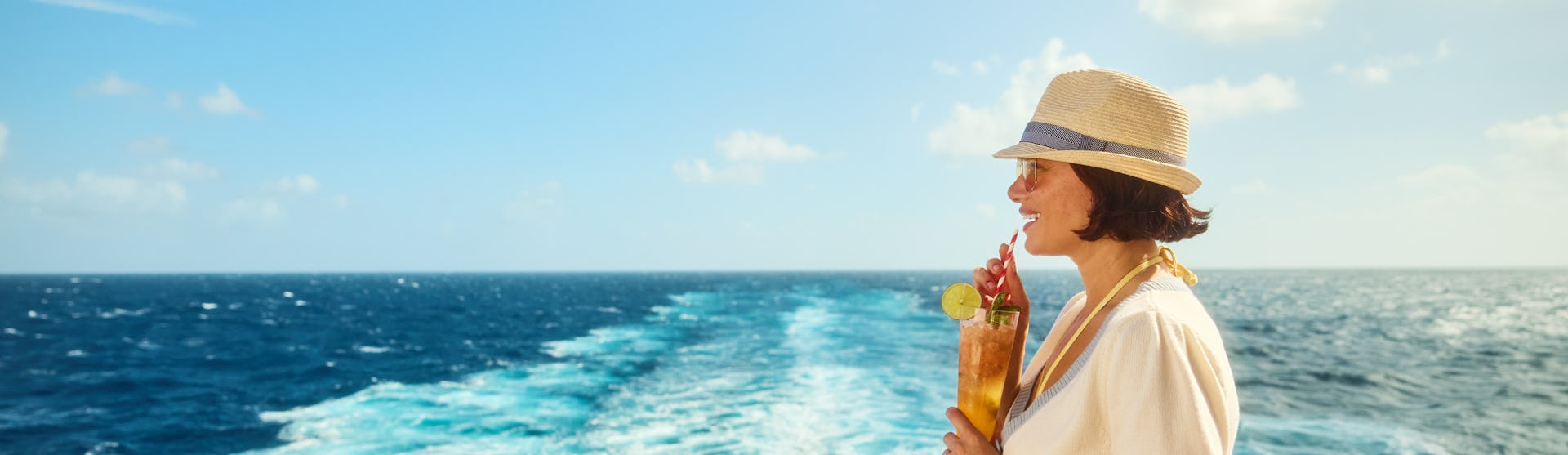 Woman with cocktail at aft of Virgin Voyages ship