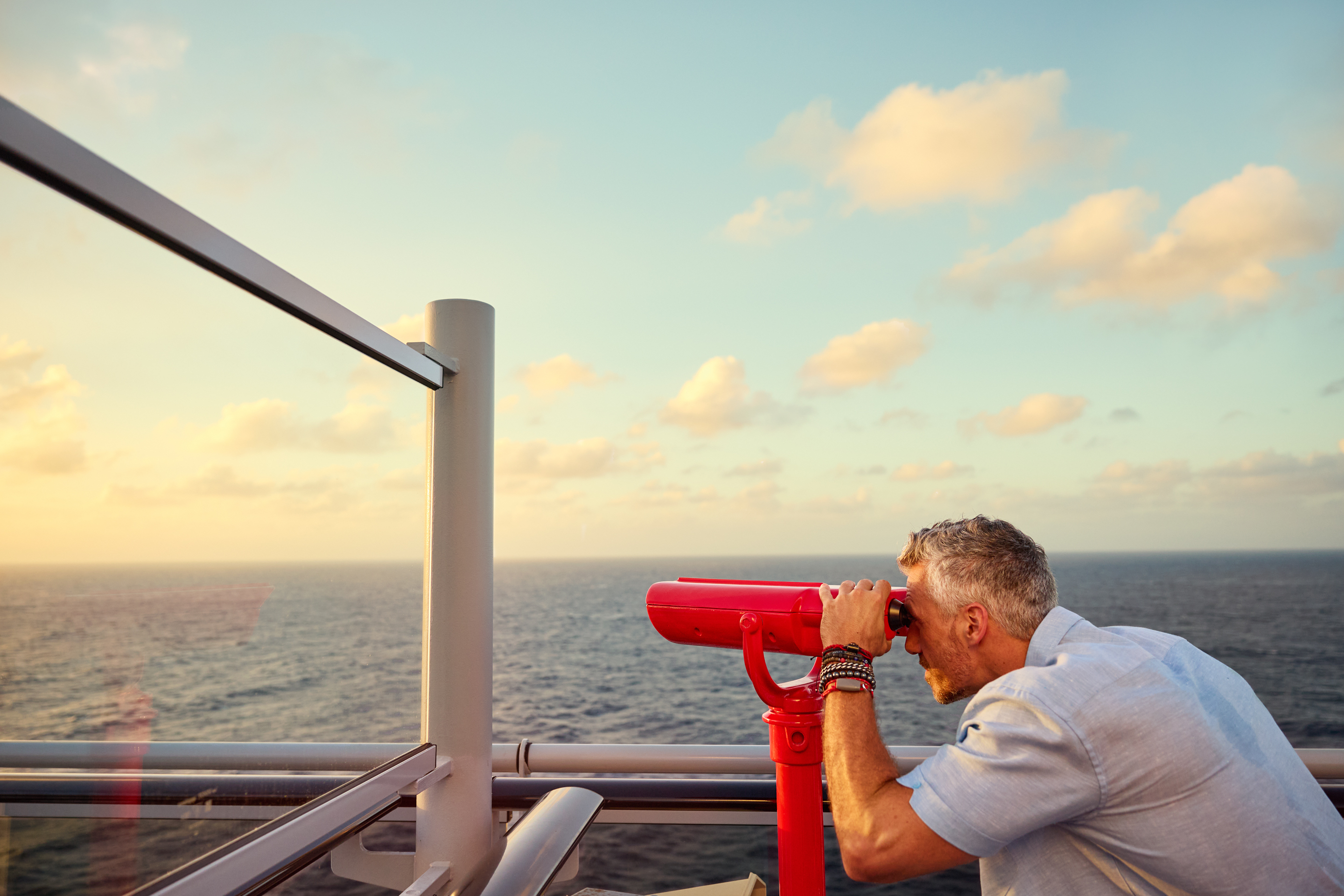 Man looking through telescope on Virgin Voyages ship
