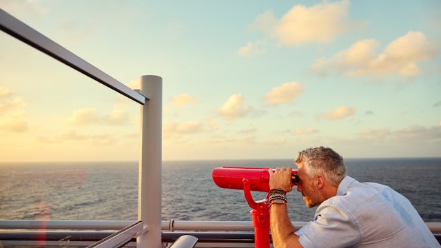 Man looking through telescope on Virgin Voyages ship